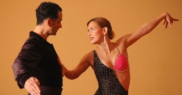 мужчина и женщина смотрят друг на друга в танце